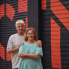 Pilar Almeria i Joan Peris, fundadors de la Companyia Teatre Micalet, davant la persiana pintada de L'ESPAI CTM